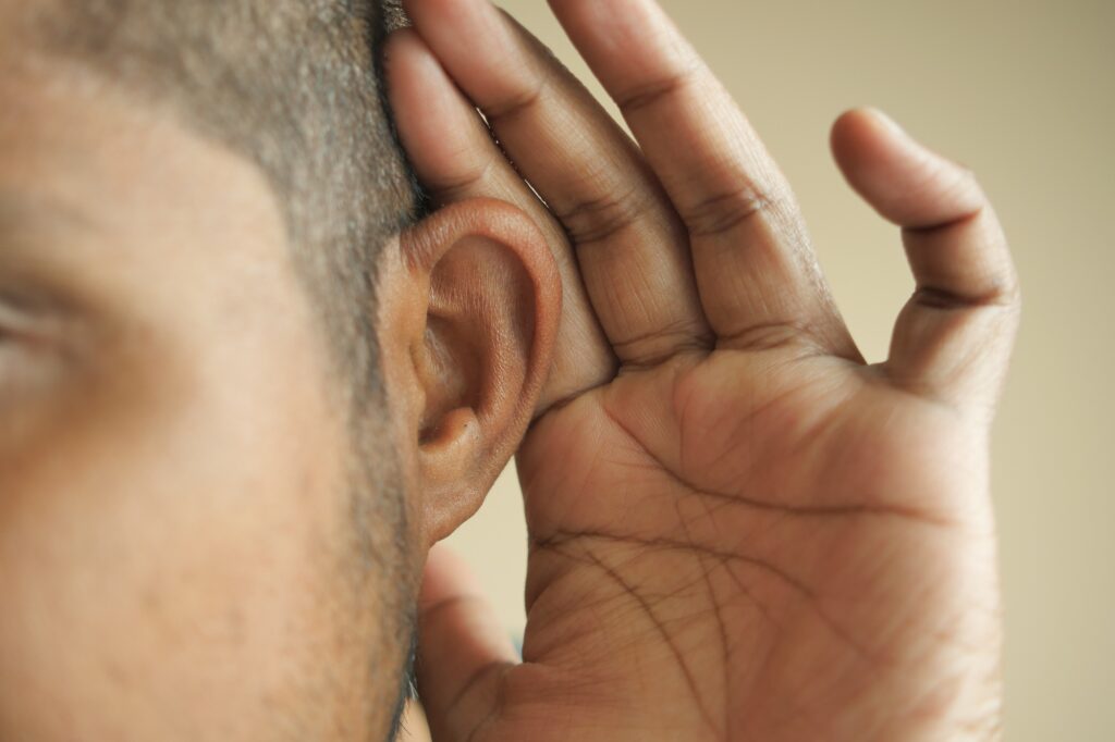 young man having ear pain touching his painful ear ,