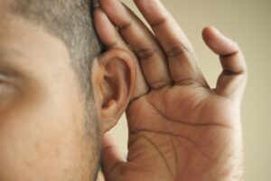 young man having ear pain touching his painful ear ,